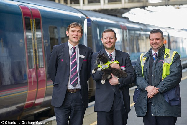 The beloved cat is pictured here being held by Andy McClements, Customer Services Team Leader, with  Andy Croughan, Station Manager (left) and Chris Bamford, Customer Services Assistant (right)