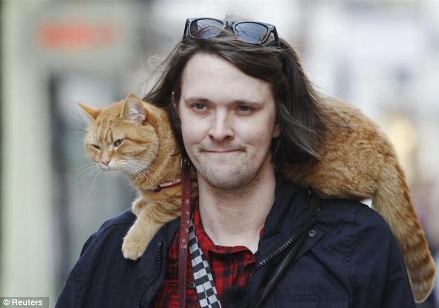 The pair turn heads on the street as Bob happily sits on Mr Bowen's shoulders